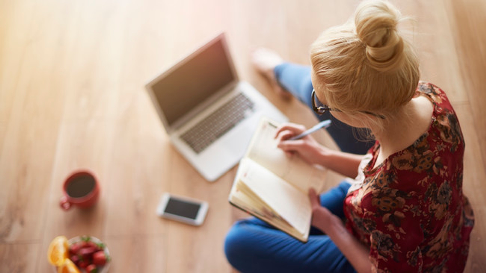 Woman sitting on floor working at laptop