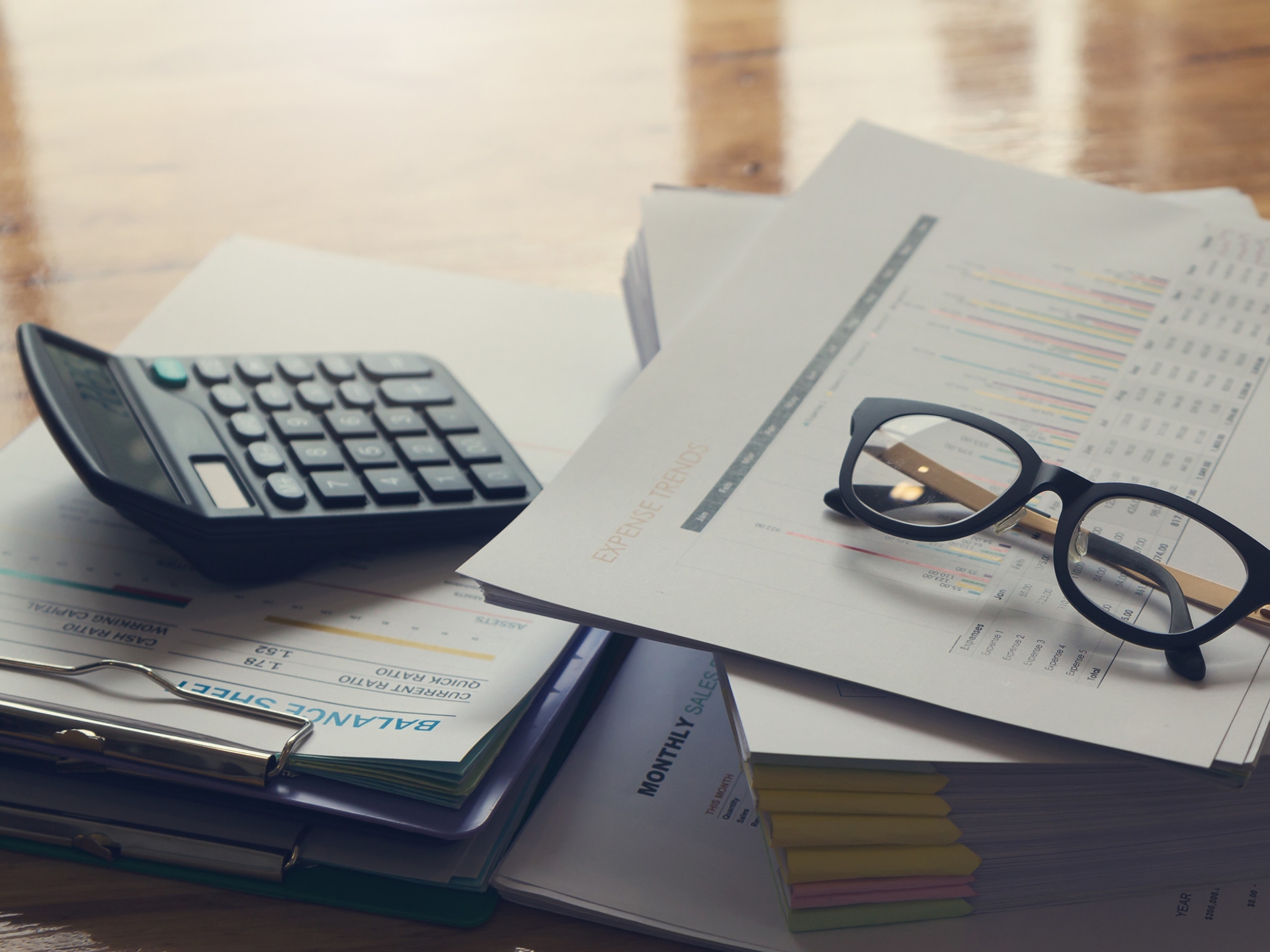 Glasses and calculator on desk on top of balance sheet