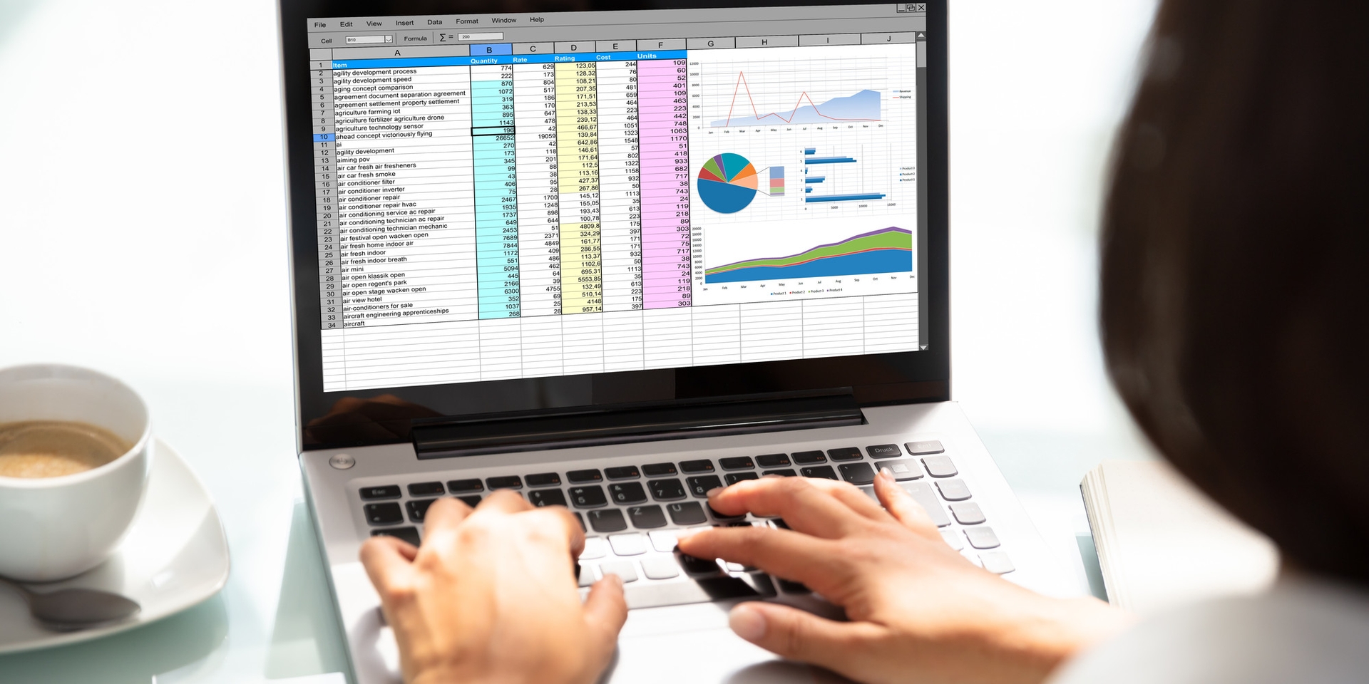 Person working on a spreadsheet and graphs on a laptop