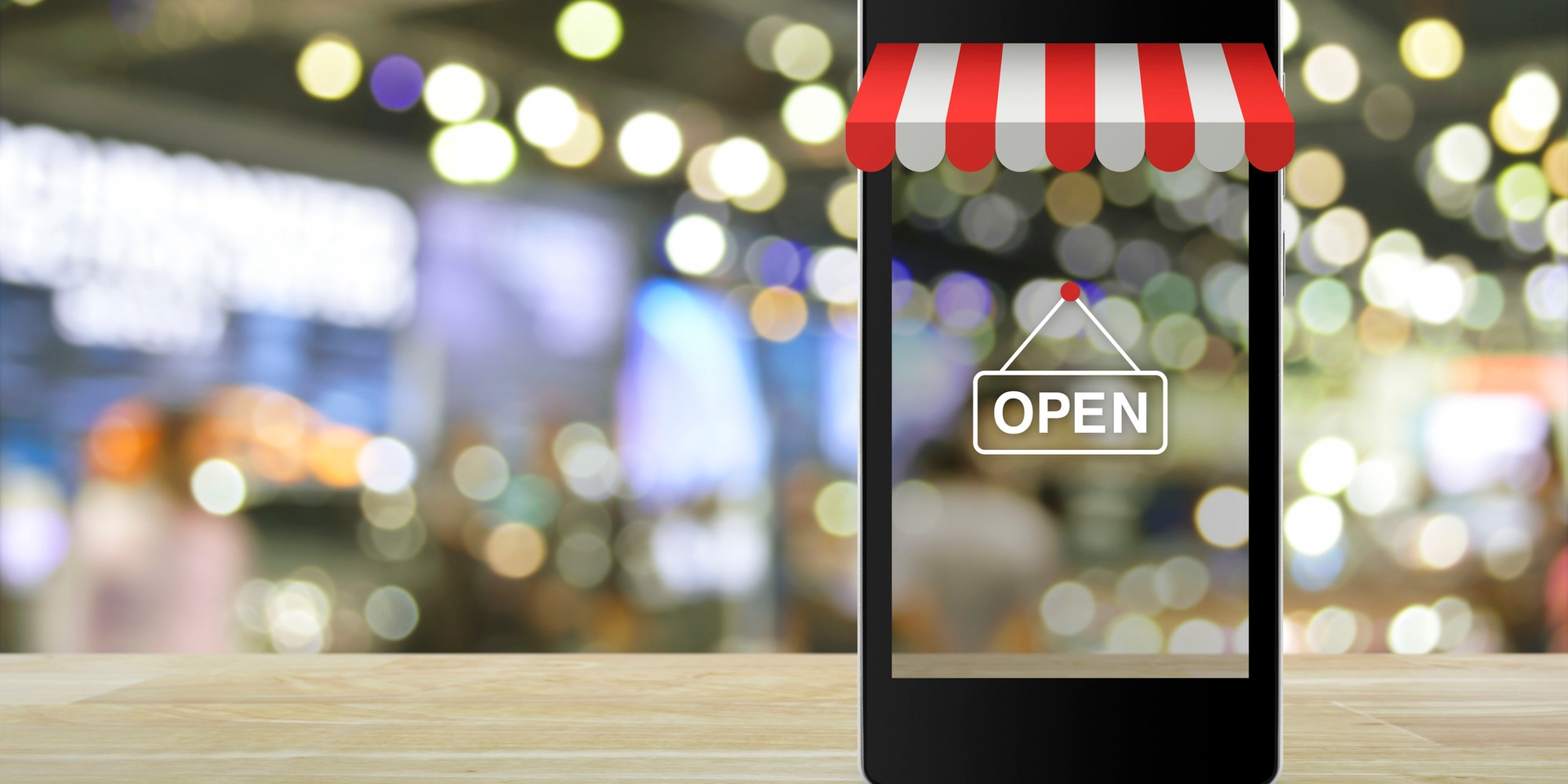 An iPhone template with an open sign and shop front and blurred background of a retail environment